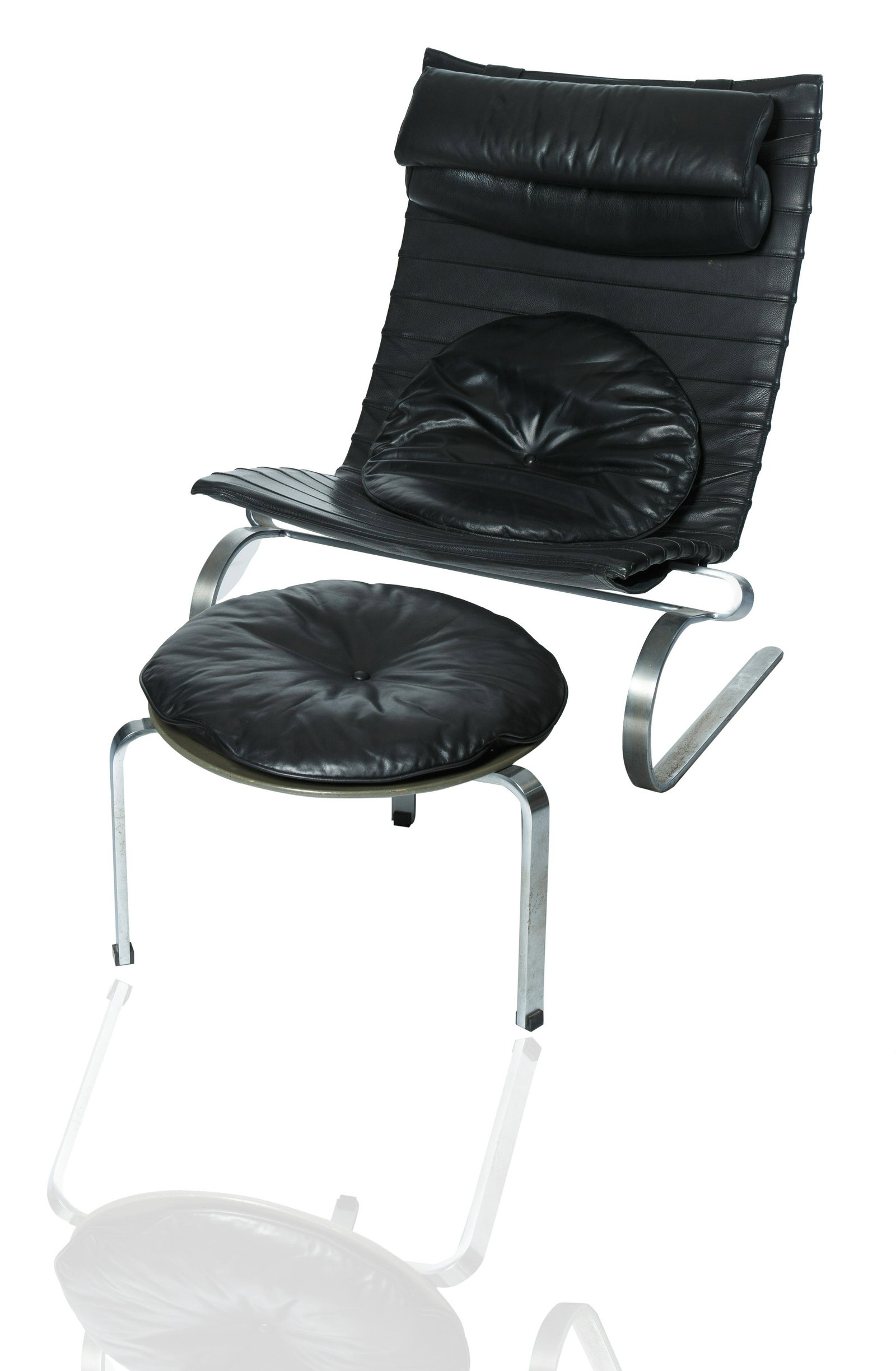 A Leather Poul Kjaerholm PK 20/ PK20 Lounge Chair: A Leather Poul Kjaerholm PK 20/ PK20 Lounge Chair shaped in a reclining position with black leather upholstered seat, cushion, pillow and conforming stool, manufacture label underside of chair; height