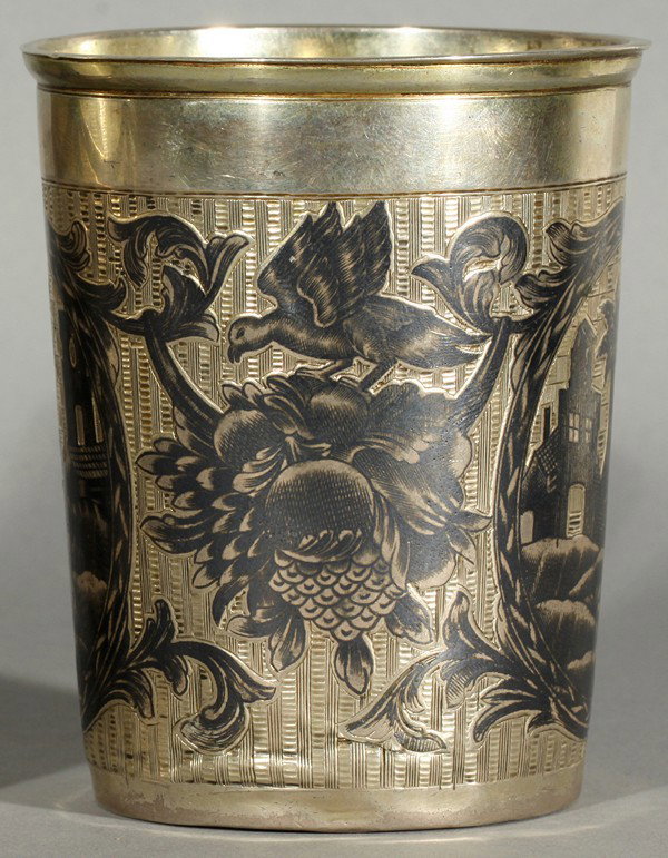RUSSIAN SILVER AND NIELLO BEAKER 1814: A RUSSIAN SILVER AND NIELLO SILVER BEAKER, 1814, the silver beaker with two exotic niello scenes featuring urban landscapes with palm trees, surrounded by flower festoons with birds and fruit, height: