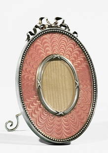 FABERGE SILVER AND GUILLOCHE ENAMEL PHOTO FRAME: SILVER AND GUILLOCHE ENAMEL FABERGE PHOTO FRAME, 1899-1908, of oval shape, the engine-turned ground covered with translucent pink enamel surrounded by a border of silver beads, frame crowned by a cast