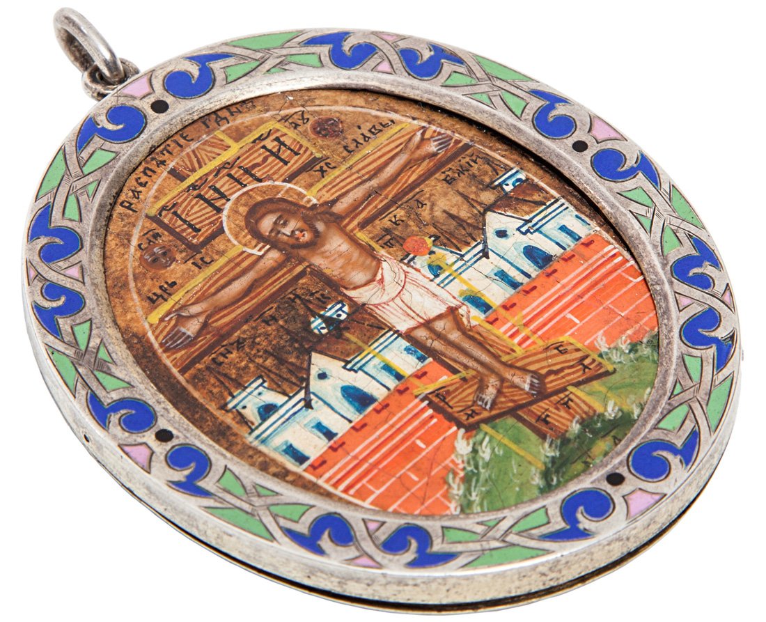 A MINIATURE ICON OF THE CRUCIFIXION IN A SILVER CHAMPLE: A MINIATURE ICON OF THE CRUCIFIXION IN A SILVER CHAMPLEVE ENAMEL FRAME, MAKERS MARK PW, ST. PETERSBURG, 19TH CENTURY, the figure of Christ on the Cross with a townscape behind him, the silver frame wi