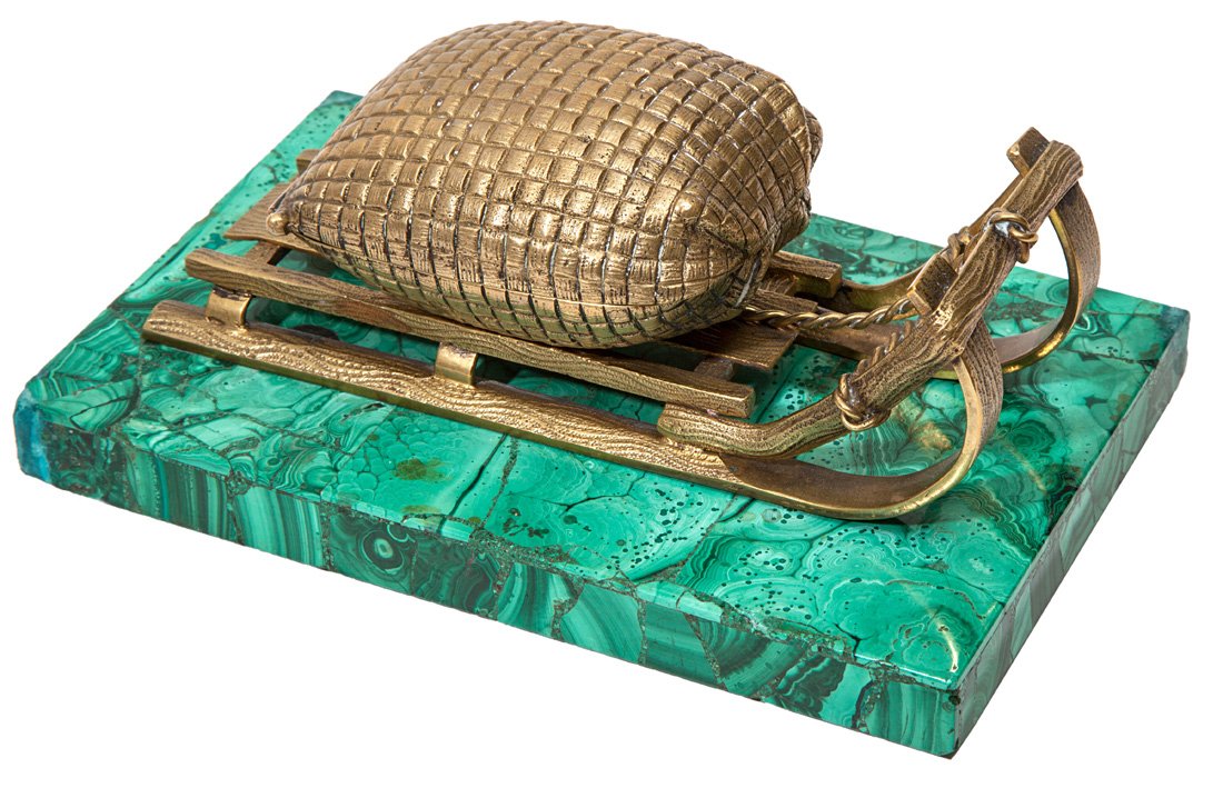 A GILT BRONZE SLED SHAPED INK WELL ON A MALACHITE BASE,: A GILT BRONZE SLED SHAPED INK WELL ON A MALACHITE BASE, a hinged container in the shape of sack laying on a sled, on a malachite base, inscribed 'Venetian Room' on inside of sack, length: 8.5 cm. (7 �