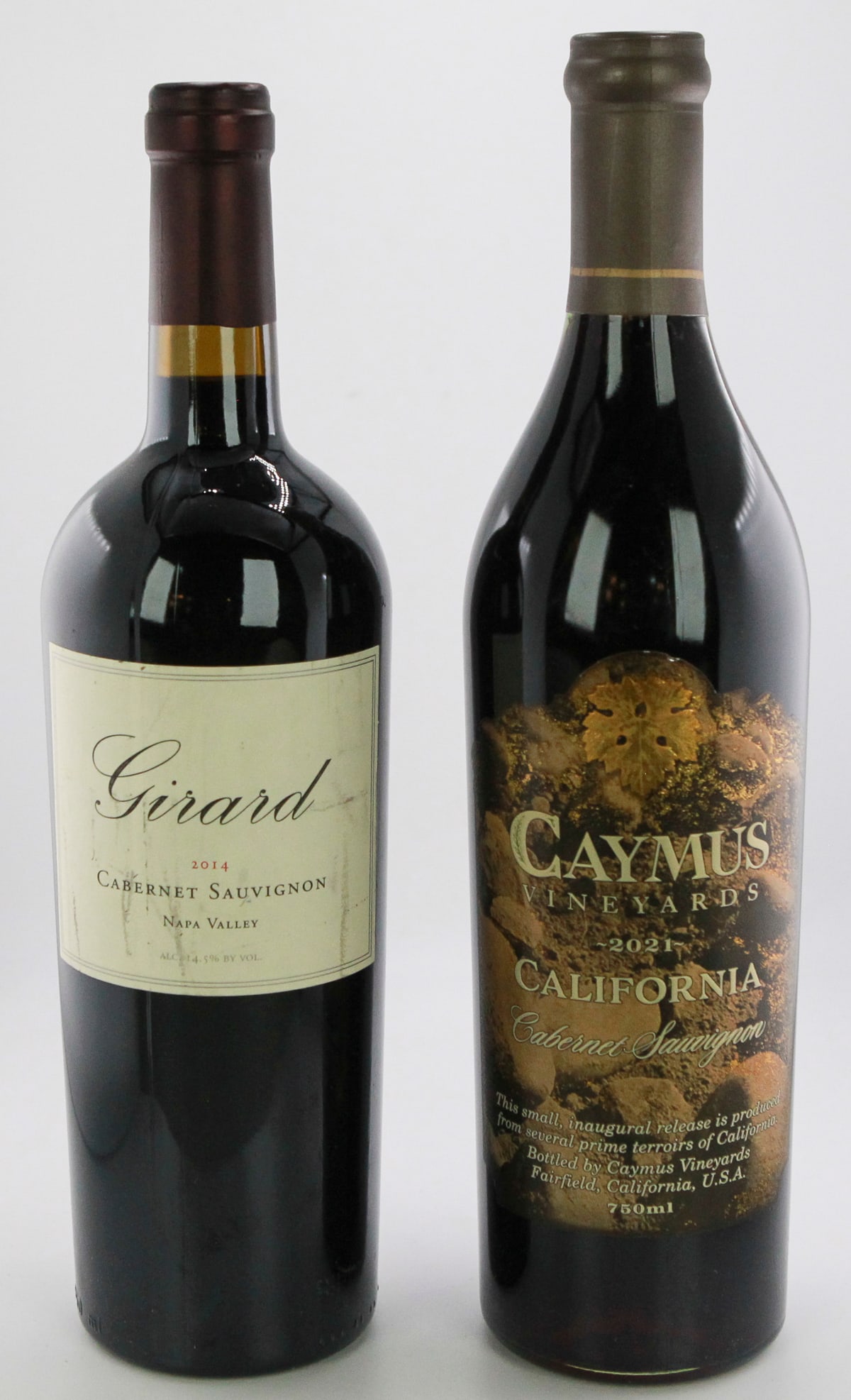 Lot of 2 Wines/Girard Cabernet Sauvignon Napa Valley 2014 & Caymus Vineyards California Cabernet: A premium Cabernet Sauvignon pairing featuring the Girard 2014 from Napa Valley, known for its deep blackberry and dark cherry notes with structured tannins, alongside the Caymus Vineyards 2021 Califo
