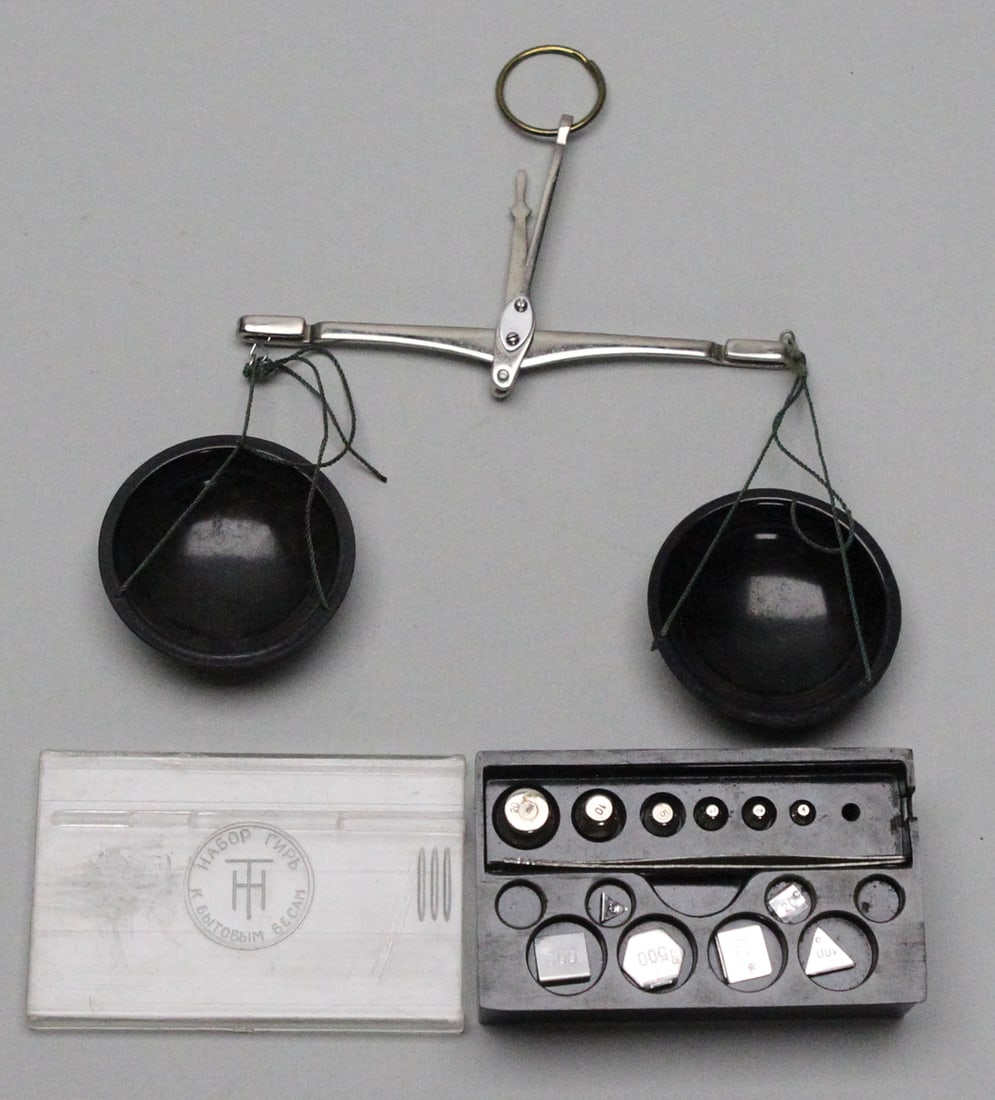 Vintage Soviet Antique Hanging Balance Beam Scale: This vintage Soviet-era hanging balance beam scale is crafted from metal and measures approximately H7 x W5 x D3 in., complete with its original set of precision weights neatly stored in a fitted case