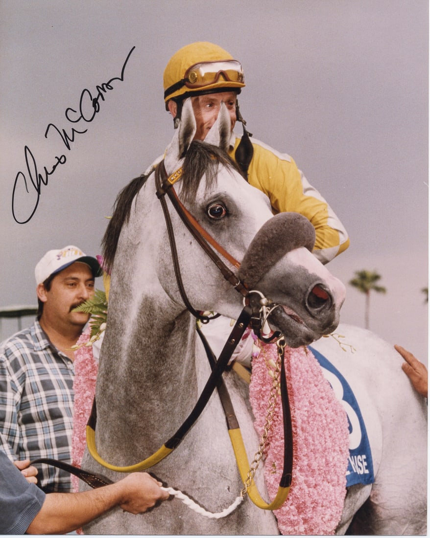 Chris McCarron / Free House Win at Santa Anita – Signed 8x10 Photo: Color 8x10 photo of jockey Chris McCarron aboard Free House after winning the Santa Anita Handicap on March 6, 1999. The image captures the victorious pair draped in a garland of pink flowers, with vi