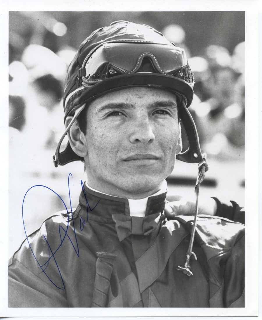 Laffit Pincay Jr. / Signed 8x6 Portrait Photograph: Black-and-white 8x6 portrait of legendary jockey Laffit Pincay Jr., captured in riding silks and helmet with goggles. Boldly signed in blue ink, this close-up image highlights his focused expression a