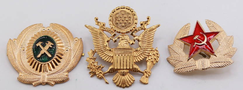 Lot of 3 Military Hat Insignia Pins – U.S. & Soviet Era: Collection of three vintage military hat insignia pins, including a Soviet red star with hammer and sickle, a U.S. Great Seal eagle emblem, and a gold-toned crossed hammer and pick emblem possibly den