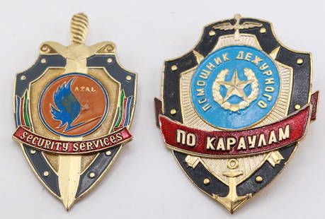 Lot of 2 Security Service and Russian Guard Shield Pins: Pair of detailed enamel and metal security-themed shield pins, one marked “AZAL Security Services” with vibrant colors and sword motif, the other featuring Cyrillic script reading “????????