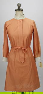 Vintage Warner Bros. Studios Movie Costume Dress – Peach with Ivory Trim: This vintage costume dress from the Warner Bros. Studios wardrobe archive features a peach-toned mini dress with subtle vertical striping, ivory collar and cuffs, and a matching tie belt at the waist.