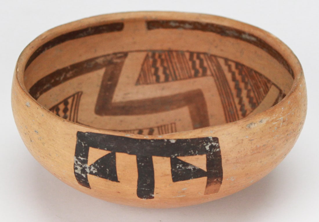 Jeddito Yellow Ware Hopi Bowl: This Jeddito Yellow Ware Hopi bowl features traditional geometric and linear motifs hand-painted in dark slip on a warm yellow clay body, adorning both the interior and exterior surfaces. Measuring ap