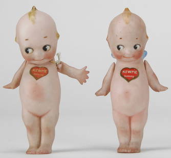 Pair of Antique German Bisque Porcelain Kewpie Dolls with Labels: Charming pair of antique bisque porcelain Kewpie dolls, both made in Germany and retaining their original red heart "KEWPIE Germany" chest labels. Each doll features hand-painted facial details, molde
