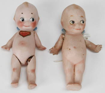 Pair of German Bisque Porcelain Kewpie Dolls by Rose O'Neill: This charming pair of vintage bisque porcelain Kewpie dolls, each measuring approximately 5 x 2.25 x 1.5 inches, were made in Germany and designed by Rose O'Neill. One doll is jointed with poseable le