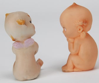Pair of Seated Kewpie Dolls – One Porcelain, One Rubber