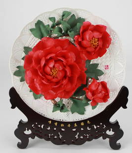 Chinese Decorative Peony Porcelain Plate with Carved Wood Stand and Silk Box: This intricately crafted Chinese decorative plate features three vibrant red peony blossoms in high-relief ceramic against a delicate lattice-style porcelain background, symbolizing wealth and honor