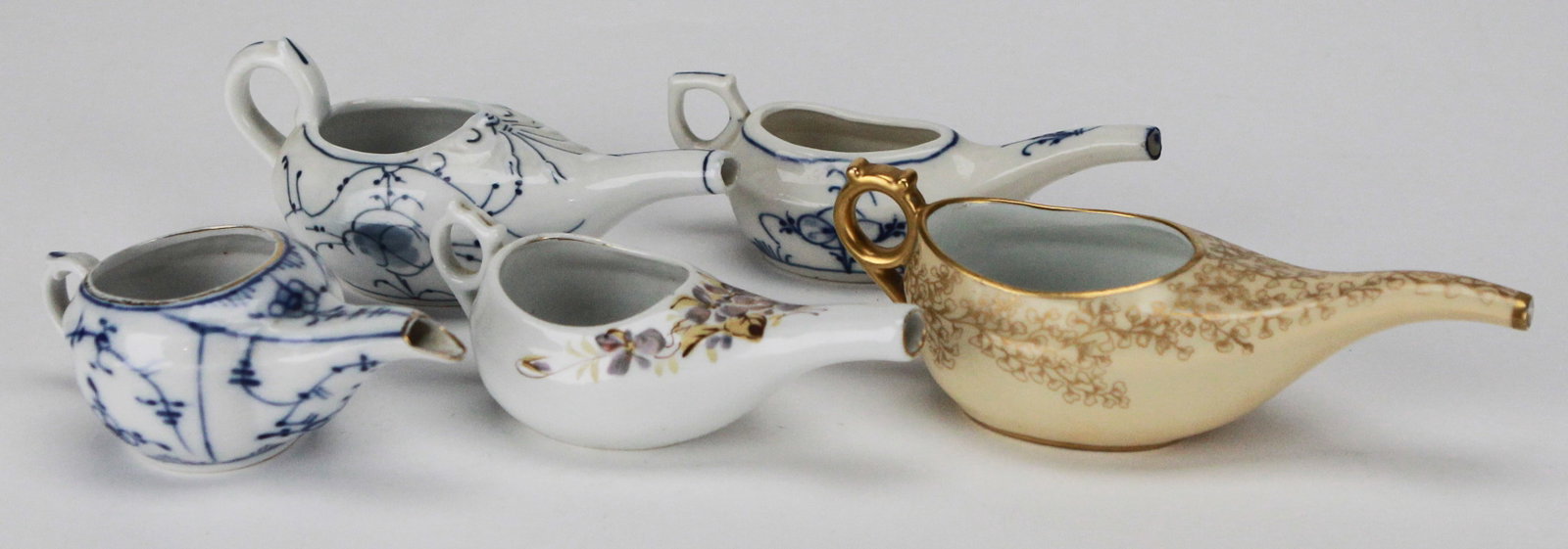 Lot of 5 Vintage German Porcelain Feeders with Blue and Gilt Accents: This lot features five charming vintage German porcelain feeders, each delicately hand-painted in traditional blue florals, scrolls, and gold embellishments. One piece is dated 1912 and marked with a 