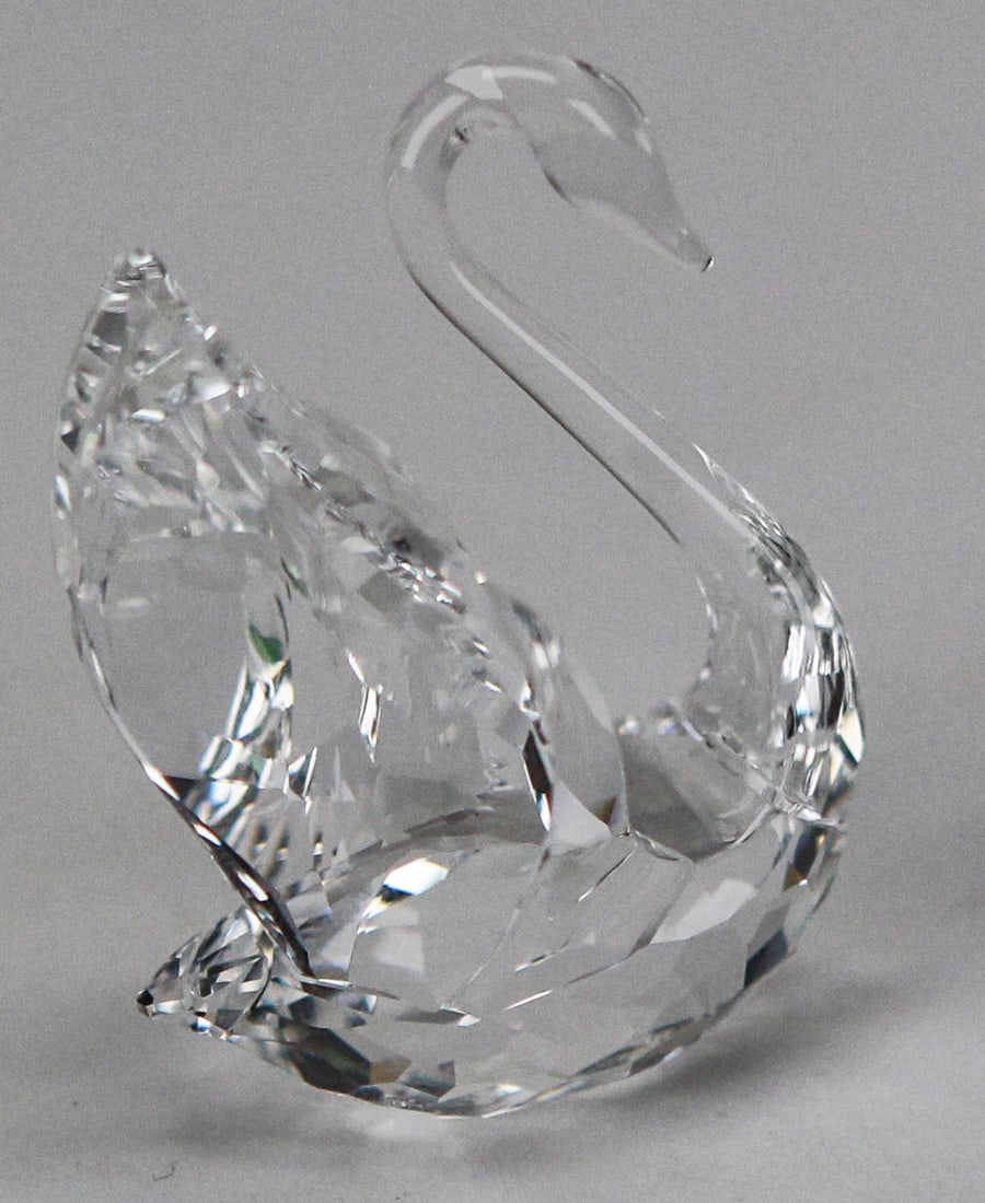 Swarovski Crystal Small Swan Figurine with Original Box: This petite Swarovski crystal swan figurine is a charming example of the brand’s delicate artistry, measuring approximately 2 x 1½ x 1 inches. Finely faceted clear crystal wings contrast with