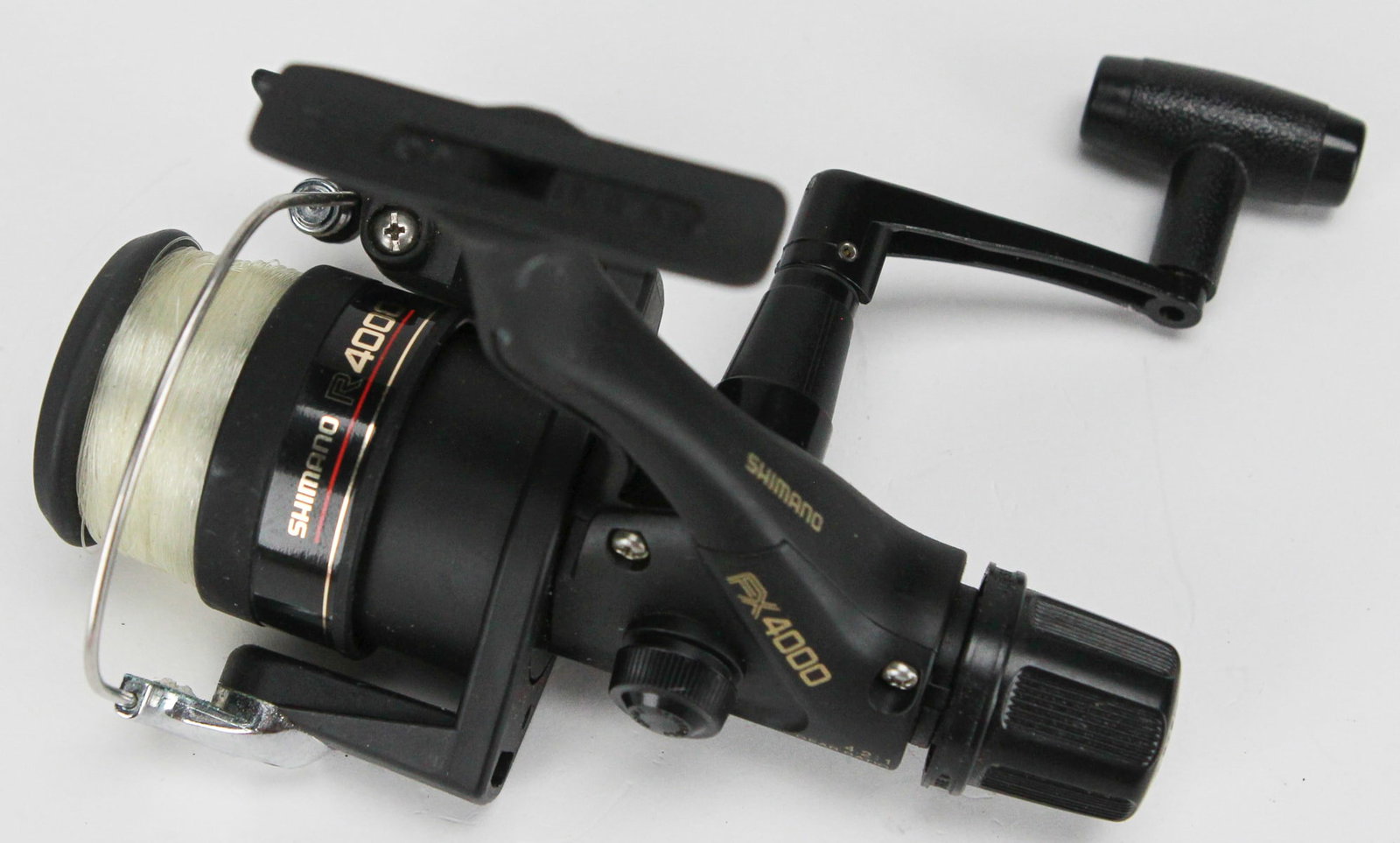 Shimano FX4000 Spinning Fishing Reel with Line and Manual: This Shimano FX4000 spinning fishing reel is part of the FX Series and comes pre-spooled with monofilament line and its original instruction manual. Designed for smooth casting and reliable performanc
