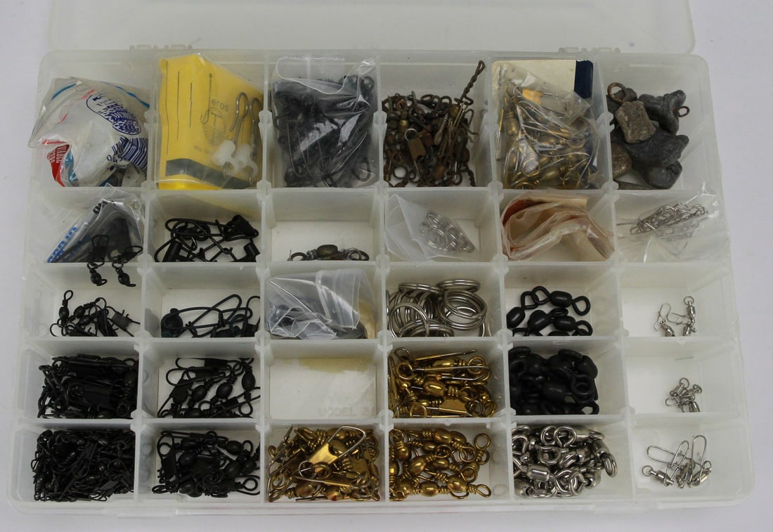 Lot of Fishing Swivels in Compartment Box: This well-organized lot features an extensive assortment of fishing swivels, including a variety of barrel, snap, and ball-bearing types in multiple finishes such as black, brass, and stainless steel.