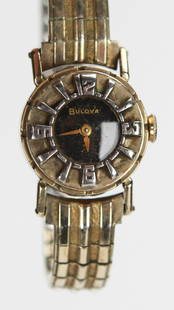 Vintage Bulova Ladies Watch – Gold-Tone with Raised Hour Markers: This vintage Bulova ladies wristwatch features a striking gold-tone case and matching expansion band, complemented by a glossy black dial and dramatic raised silver-tone numerals. The compact 1-inch f