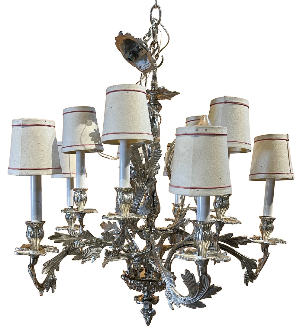 French Eight-Light Silvered Metal Chandelier with Crystal Accents: Elegant French-style eight-light chandelier featuring a silvered metal frame with richly cast acanthus leaf and foliate scroll arms surrounding a twisted central standard. Each candle-style light is
