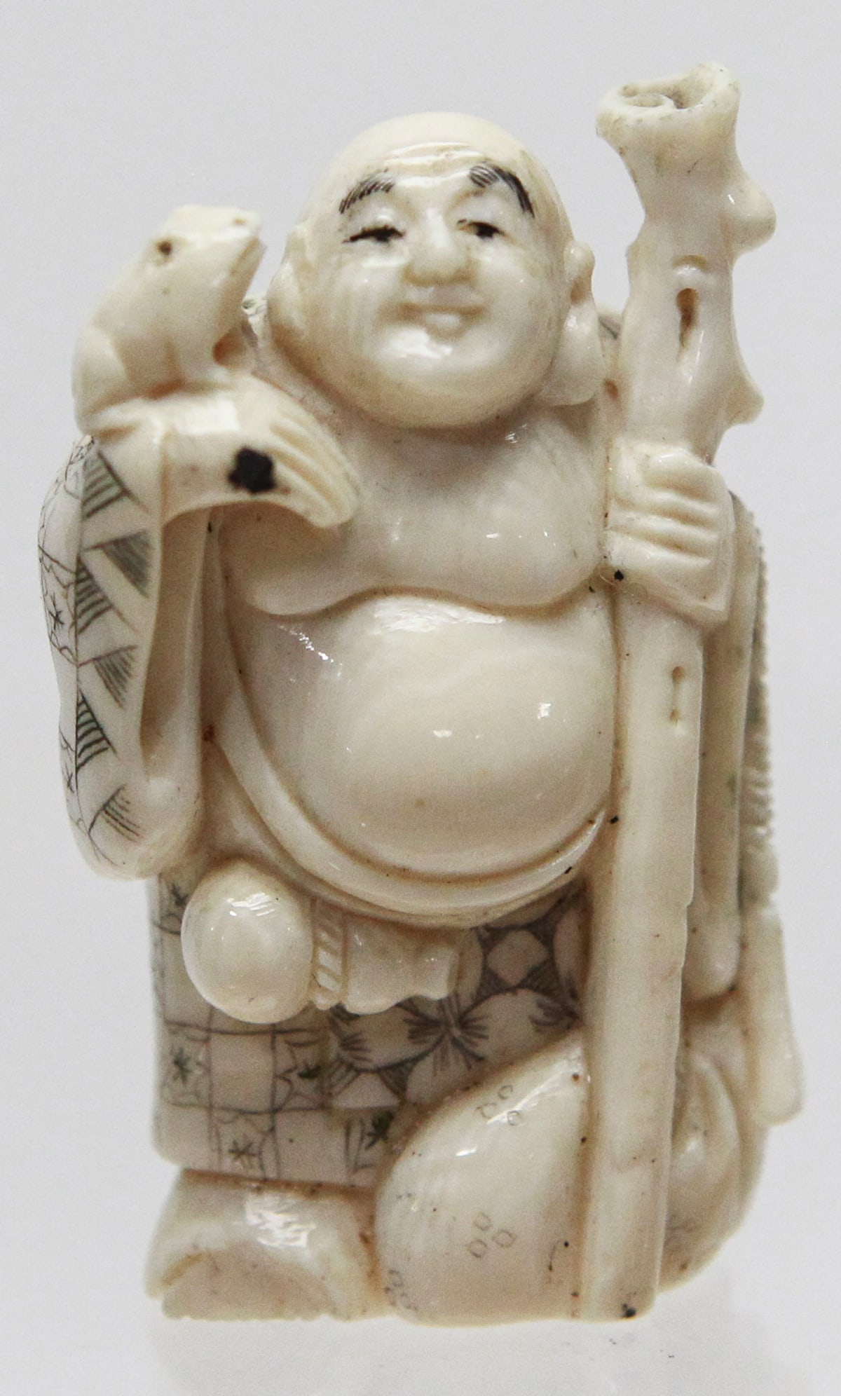 Vintage Japanese Carved Hotei with Staff and Frog Netsuke Signed: Vintage Japanese carved netsuke depicting the smiling deity Hotei standing with a walking staff in one hand and a frog perched on his shoulder. He is shown with his characteristic exposed belly and a 