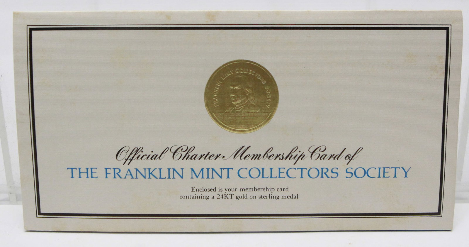 1974 Franklin Mint Collectors Society Charter Membership Card with 24KT Gold on Sterling Medal: Official 1974 Franklin Mint Collectors Society Charter Membership Card presented in its original blue presentation folder with protective plastic holder. The personalized membership card features a 24