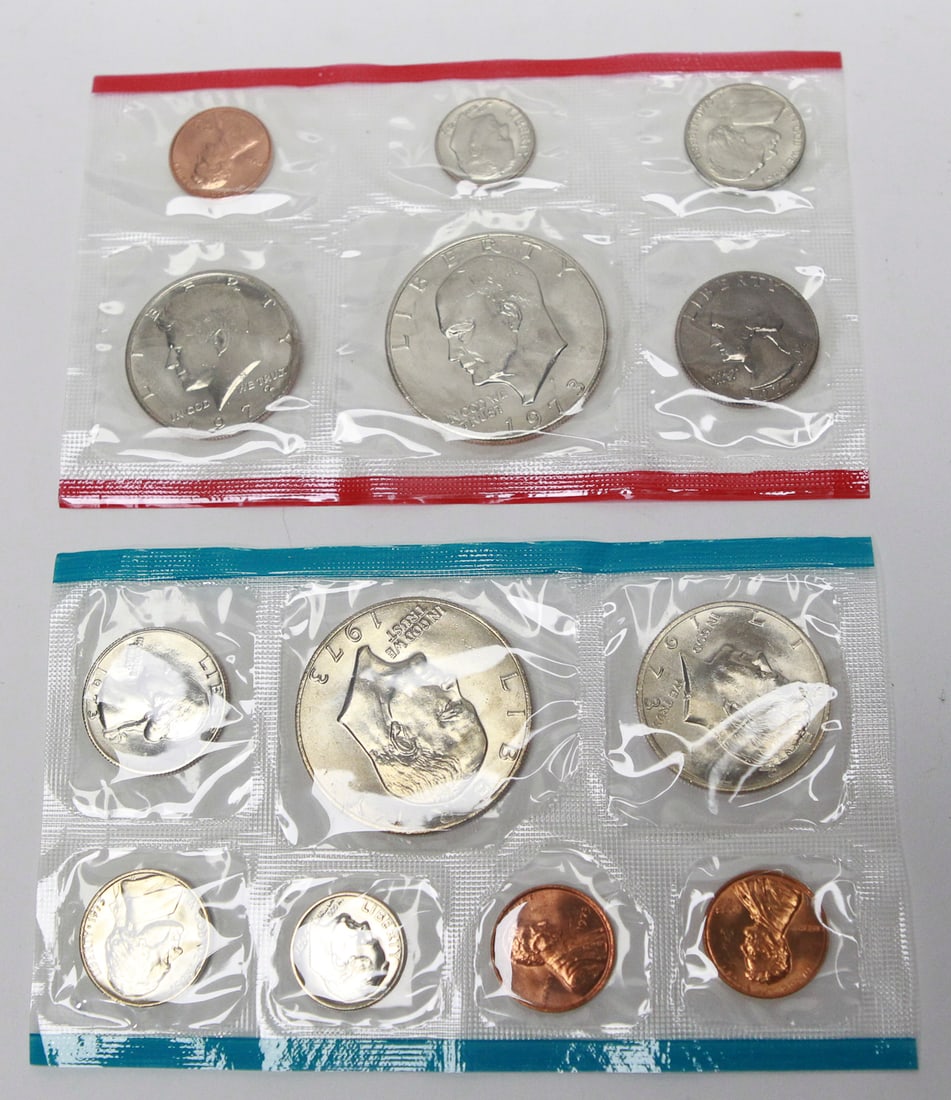 1973 United States Uncirculated Mint Set: Original 1973 United States Uncirculated Mint Set in the official U.S. Mint cellophane packaging, complete with both the Philadelphia (red seal) and Denver (blue seal) packs. The set contains all 12