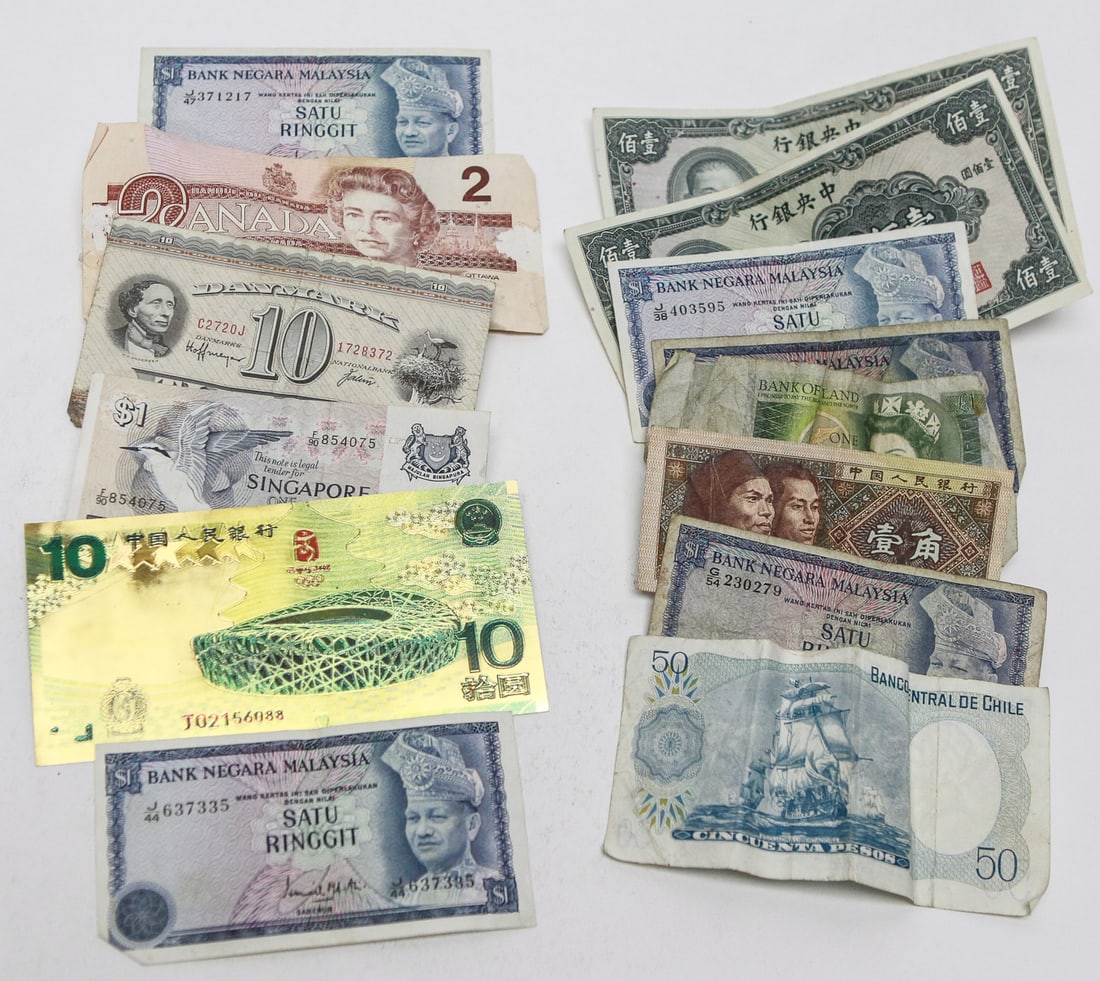 World Banknote Collection: Collection of assorted world paper currency representing multiple countries and denominations, including Canada, China, Malaysia, Singapore, Chile, Ireland, and additional international notes.