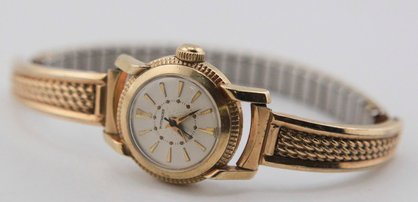 Vintage Wittnauer Ladies Gold-Tone Wristwatch: Vintage Wittnauer ladies wristwatch with gold-tone case, white dial, gold-tone baton hour markers, and black hands. Fitted with an integrated gold-tone hinged bangle bracelet. Stainless steel back mar