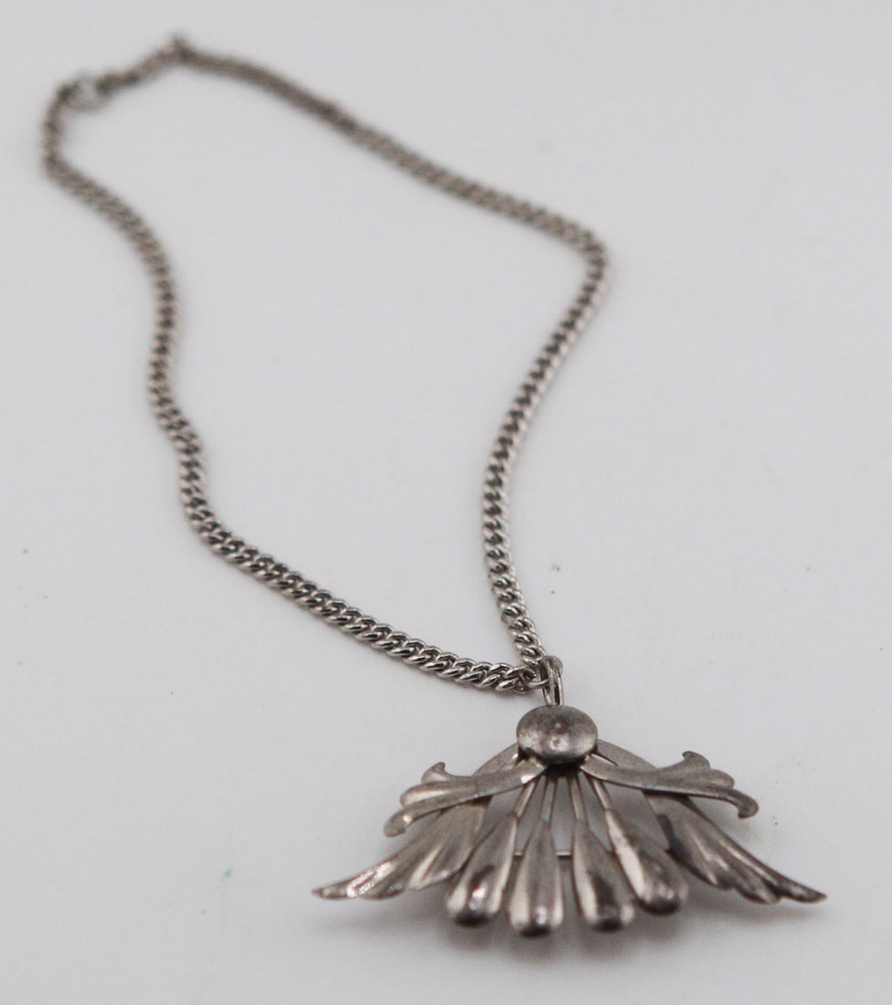 Sterling Silver Pendant Necklace: Sterling silver pendant necklace featuring a stylized fan or floral spray design with articulated radiating elements. Includes a sterling silver curb-link chain measuring approximately 18 inches.