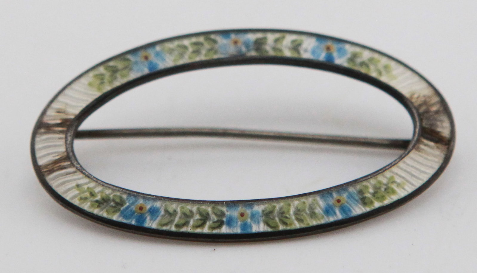 Sterling Silver Guilloché Enamel Oval Brooch: Sterling silver oval brooch featuring finely detailed guilloché enamel decoration with alternating blue floral motifs, green leaves, and white panels. Marked STERLING on the reverse. Elegant openwork