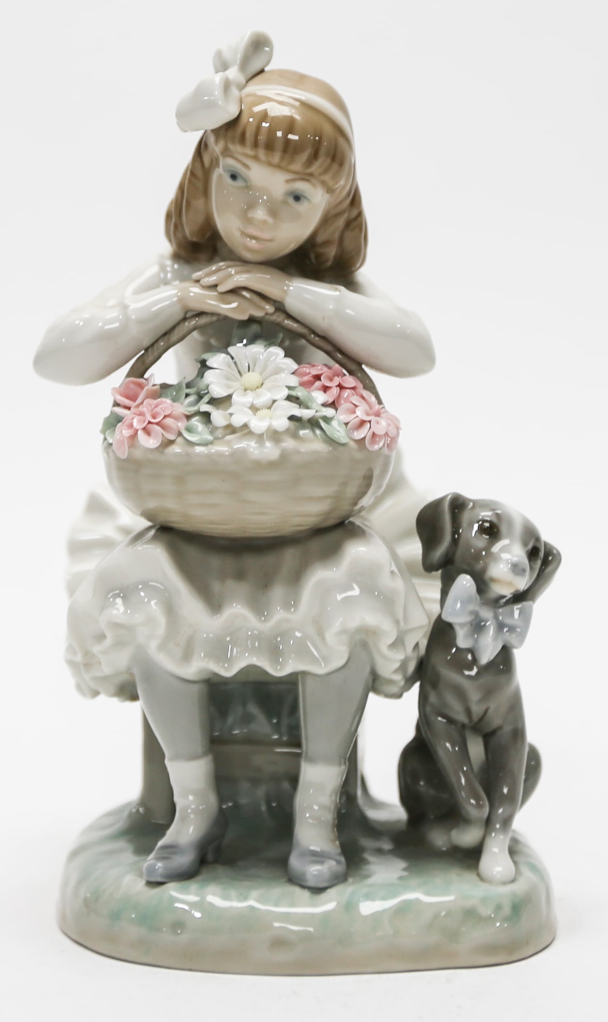 Lladró Girl with Flower Basket and Dog Figurine: Charming Lladró porcelain figurine depicting a young girl seated with a woven basket filled with delicate pink and white flowers, accompanied by an attentive dog wearing a bow. Rendered in Lladró’