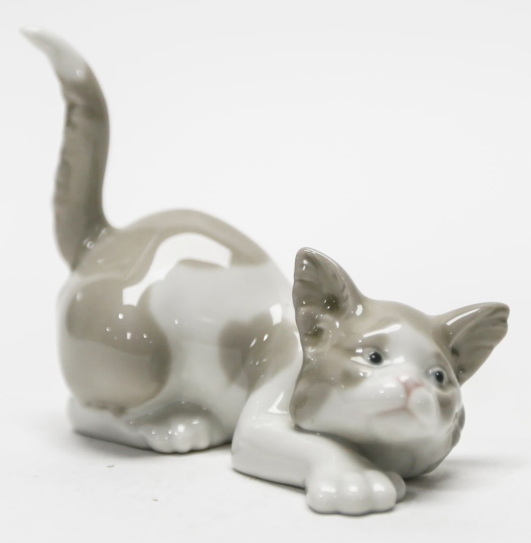 Lladro Crawling Cat Porcelain Figurine No. 5112: A retired Lladro glazed porcelain figurine titled Crawling Cat, model No. 5112, depicting a playful gray and white cat crouching with its front paws extended and tail raised. Designed by Salvador