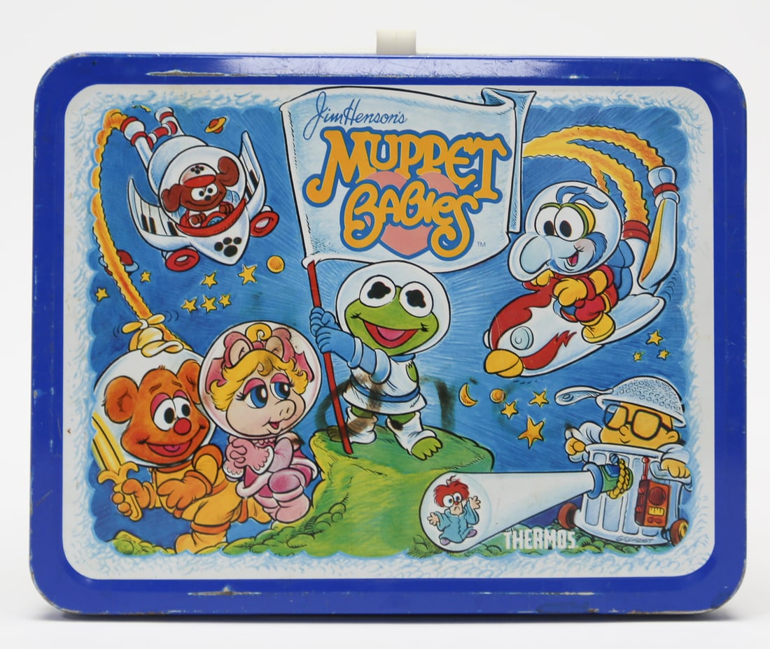 Jim Hensons Muppet Babies Metal Lunch Box: A vintage Thermos brand metal lunch box featuring Jim Hensons Muppet Babies characters in colorful space and playroom scenes, including Kermit, Miss Piggy, Fozzie, Gonzo, Animal, and others. The box h