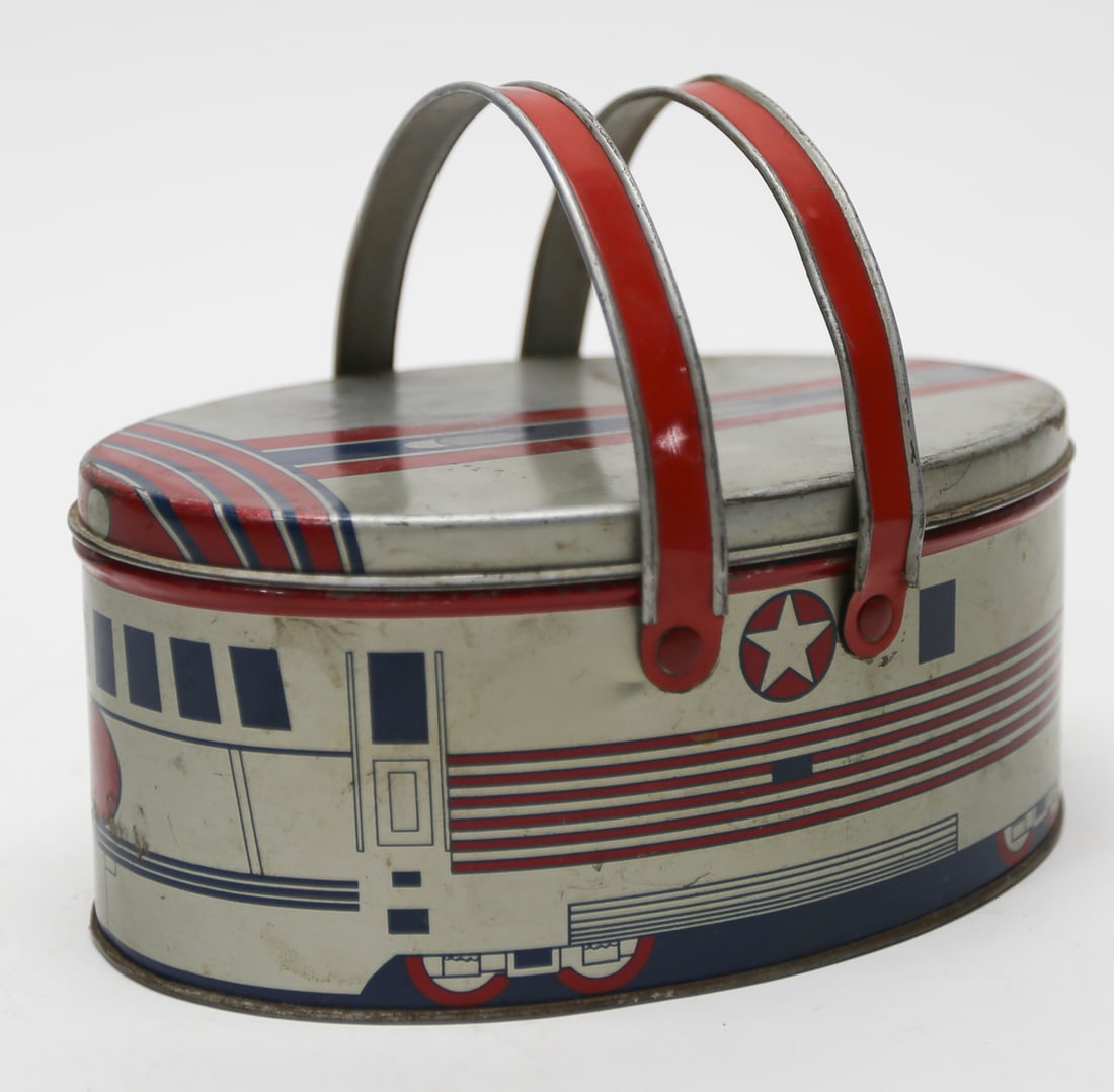 Vintage Ohio Art Streamline Train Metal Lunch Basket: An oval metal lunch basket featuring red and blue streamline train graphics with star emblems and two folding red metal handles. Measures approximately 3.5 x 8.5 inches. Marked Ohio Art on the interio