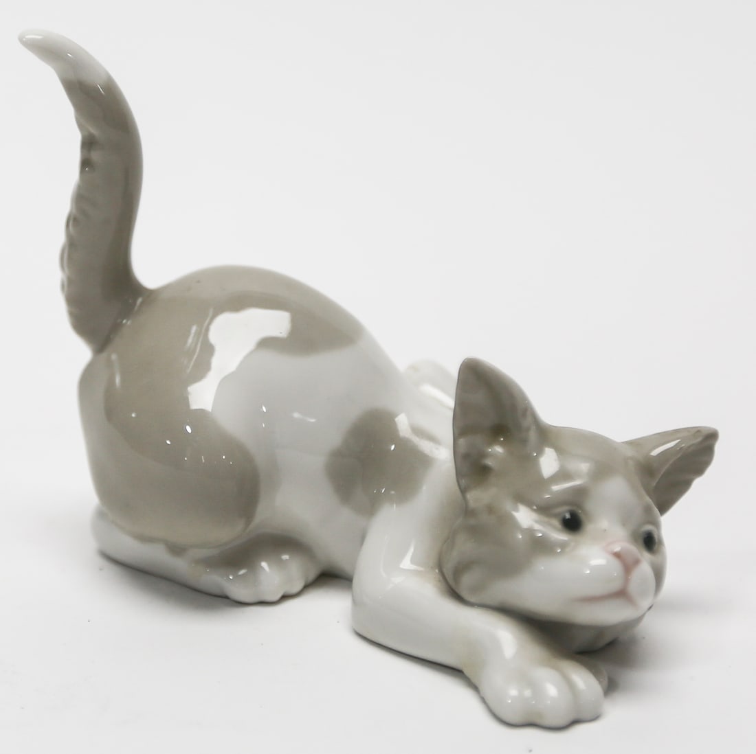 Lladro Playful Cat Porcelain Figurine Number 5112: Retired Spanish glazed porcelain figurine known as Playful Cat or Attentive Cat. The sculpture depicts a lively crouching kitten with its front paws extended head raised and long curved tail held upri