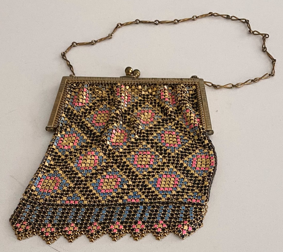Whiting & Davis Gilt Metal Mesh Purse, c. 1920s: Elegant Whiting & Davis mesh purse from the 1920s, crafted in golden metal with an intricate enameled pattern in soft pink, blue, and black. The delicate mesh body features a repeating diamond motif a