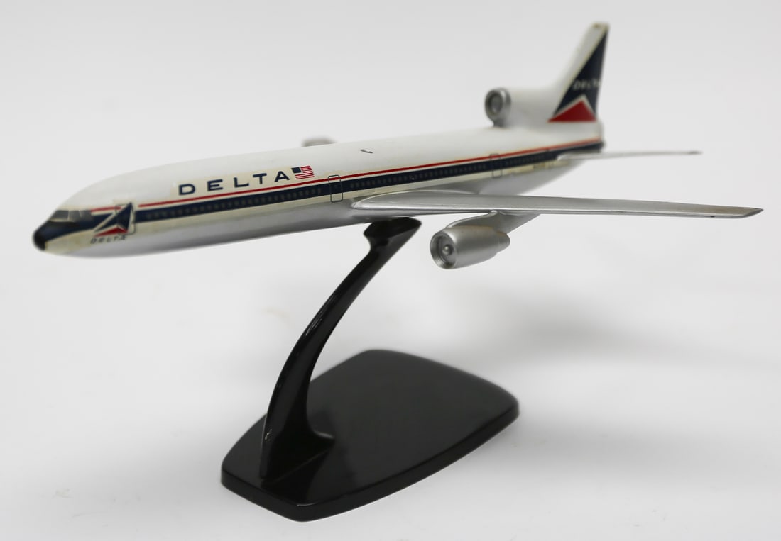 Vintage Delta Air Lines L-1011 Model Plane: Vintage Delta Air Lines Lockheed L-1011 TriStar model airplane featuring the airline’s classic red, white, and blue livery, three-engine configuration, detailed passenger windows, and a black