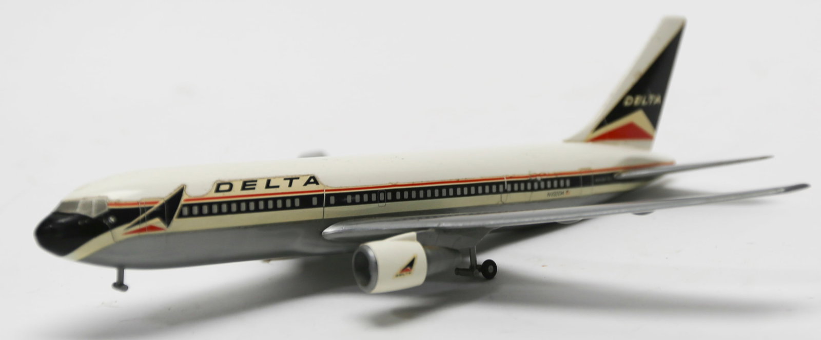 Vintage Delta Air Lines Boeing 767 Model Plane: Vintage Delta Air Lines Boeing 767 model airplane featuring the airline’s classic red, white, and blue livery, twin-engine configuration, landing gear, detailed passenger windows, and registration