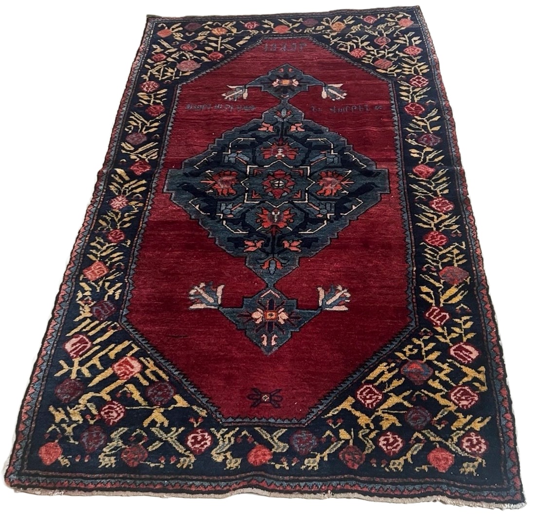 Antique 1929 Armenian Handwoven Rug: Antique Armenian handwoven wool rug dated 1929, featuring a large geometric floral medallion against a deep red field with Armenian inscriptions and stylized motifs. The composition is surrounded by a
