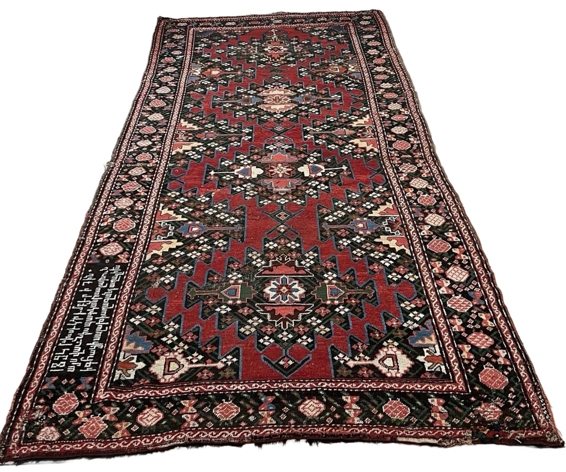 Antique Armenian Karabagh Rug Dated 1894: Antique handwoven Armenian Karabagh wool rug featuring a deep red field filled with bold geometric medallions, stylized floral motifs, and multiple decorative borders. An Armenian inscription and