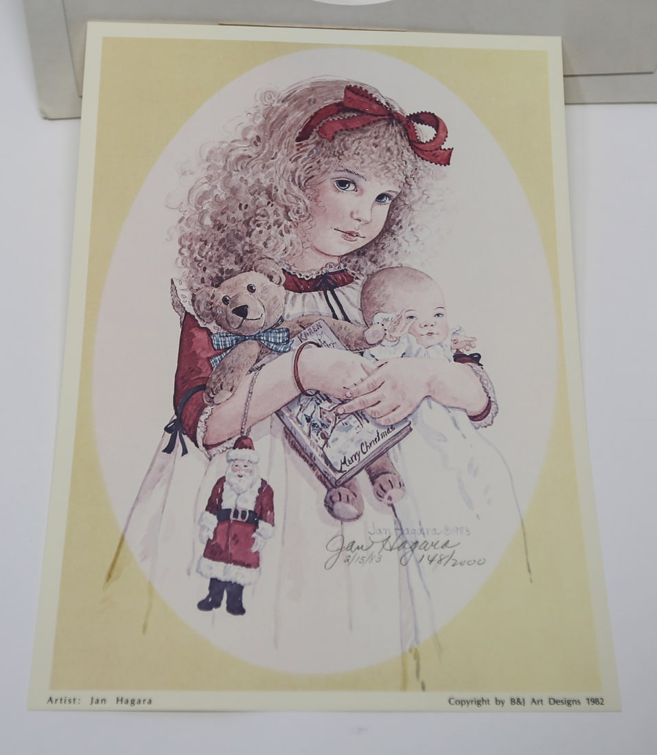 Jan Hagara Christmas Child Limited Edition Lithograph: A limited edition lithograph by Jan Hagara, depicting a young girl holding a baby doll, teddy bear, Santa figure, and Christmas book. Signed, dated February 15, 1983, and numbered 148 of 2000. Publish
