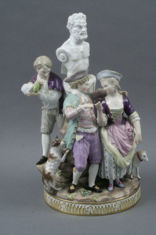 A 19th century Meissen figure group, 13.25in.: A 19th century Meissen figure group, betrothal scene, embracing male and female, a lamb and dog to their sides, two further figures to reverse side and Bacchus statue above, on circular base, crossed