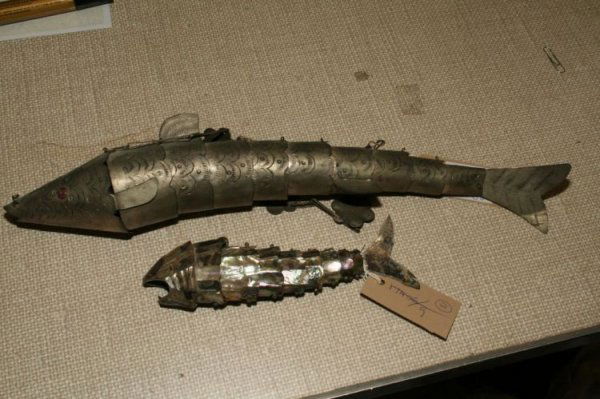 A paua shell articulated model of a fish, 17ins: A paua shell articulated model of a fish, with eleven segments and white metal mounted mouth, 7.5ins and an Indian white metal articulated model of a fish, made in eleven segments with floral hanging