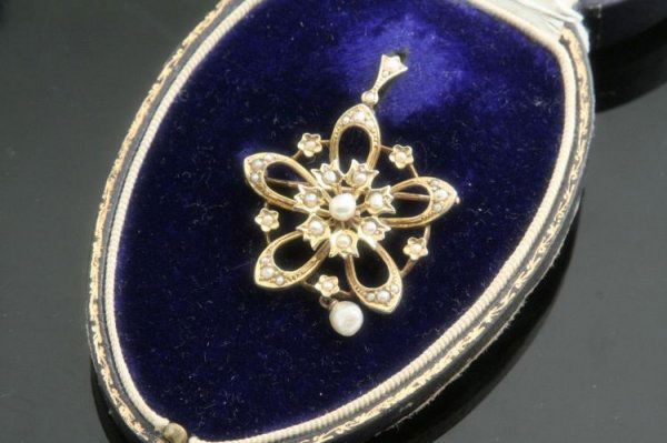 A split pearl and 9ct gold pendant / brooch: A split pearl and 9ct gold pendant / brooch, of openwork flowerhead form with small baroque pearl drop, cased by Alex Brown, Glasgow