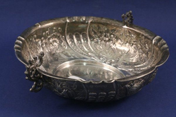 A Victorian embossed silver twin handled bowl, 10: A Victorian embossed silver twin handled bowl, shaped oval form decorated with flowerheads and foliage, Charles Stuart Harris, London 1890, 10ins