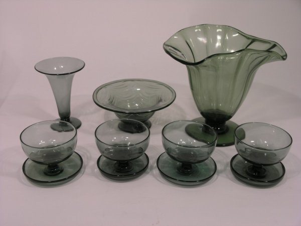 Glassware attributed to the designs of Keith Murra: Glassware attributed to the designs of Keith Murray, in green-grey glass, consisting of tall pedestal vase with frill rim (8.5in.), a moulded bowl with folded rim (7.25in.), trumpet vase (5.75in.) and