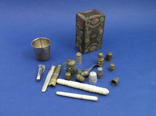 A late 19th century embossed and gilt leather nece: A late 19th century embossed and gilt leather necessaire, lacking contents, eleven brass and white metal thimbles, two bone needle cases and five other items