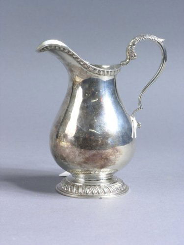 A George V silver baluster cream jug, 5.75ins: A George V silver baluster cream jug, with foliate scroll handle and gadrooned rim and base, maker Charles Stuart Harris, London, 1927, 5.75ins