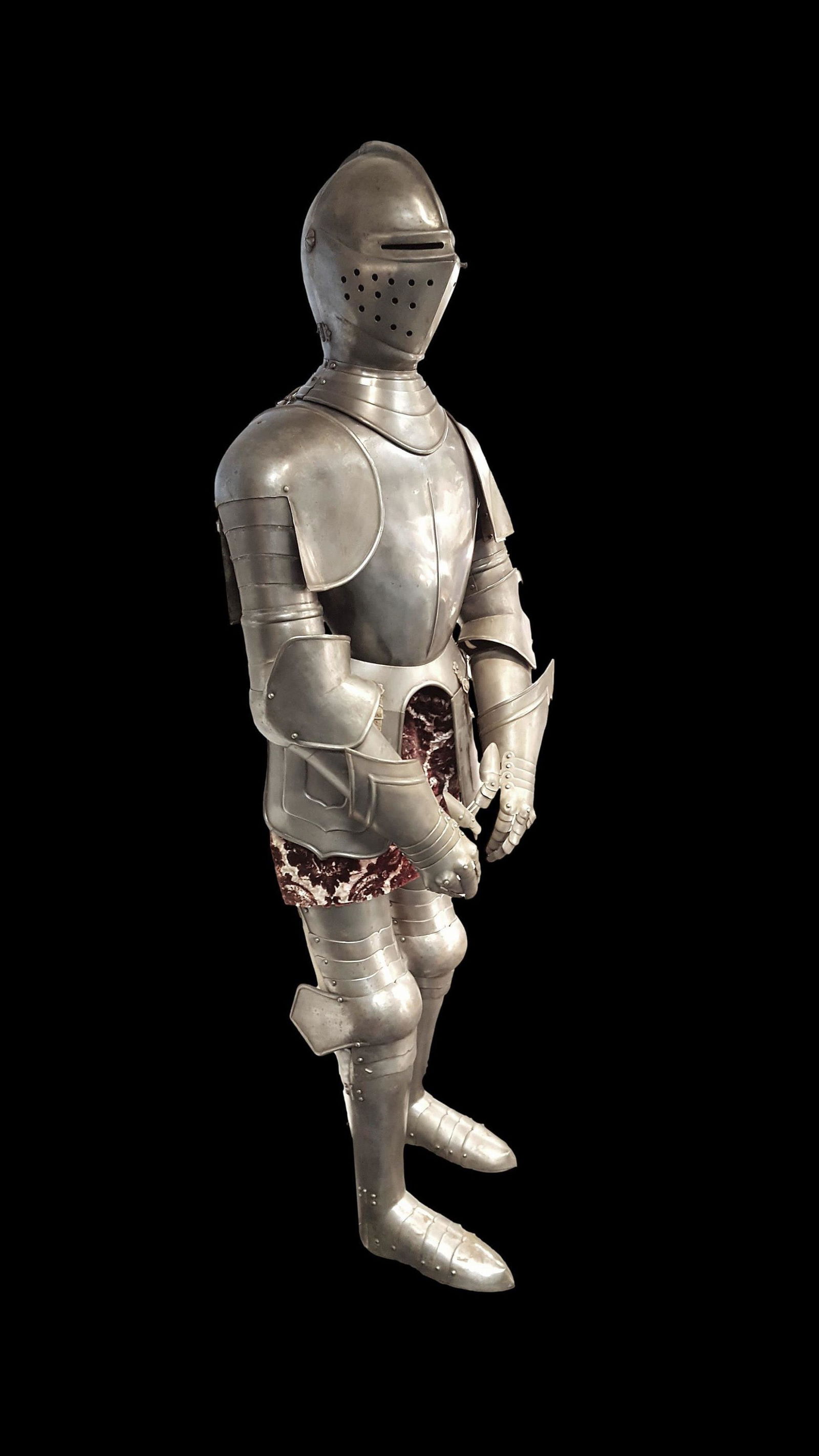 A Complete Suit of Armor in the 16th Century Italian Style: A Complete Suit of Armor in the 16th Century Italian Style. A quality made reproduction of the late 19th / early 20th century, using hand-hammered thick armor plating. Included is a black painted wood