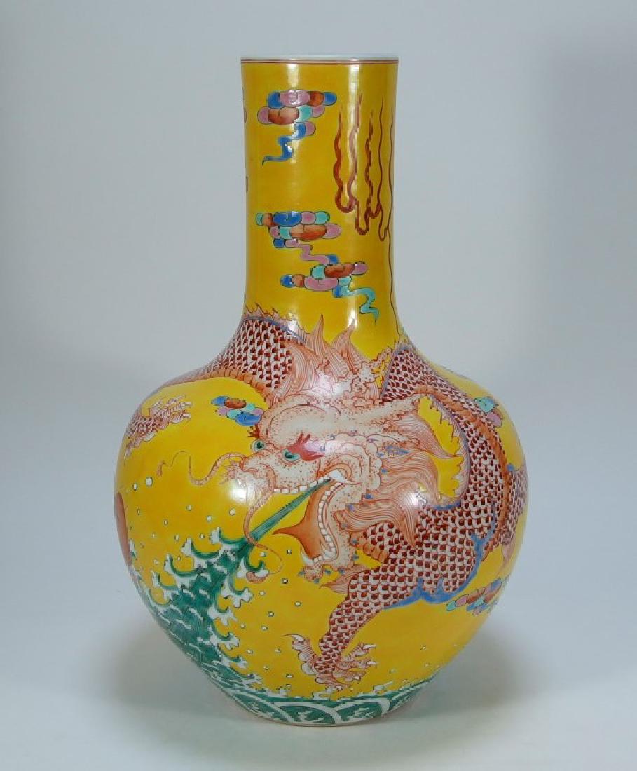 Chinese Yellow Famille Rose Porcelain Dragon Vase: CHINA, 20TH CENTURY A Chinese porcelain yellow Famille Rose dragon vase. The globular form vase is decorated with a flying dragon spewing water as a Koi fish flops. The underside bears a Kangxi mark.